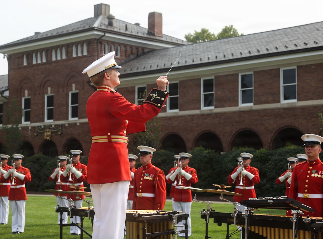 U.S. Marine Corps Capt. Courtney Lawrence, executive officer of “The Commandant’s Own” United States Marine Drum & Bugle Corps, leads a musical performance during a change of command ceremony at Marine Barracks Washington, D.C., July 16, 2026. The ceremony included the passing of the organizational colors from the outgoing to the incoming commander, symbolizing the transfer of authority, responsibility, and accountability for the command, and featured marching and musical elements from Marine Barracks Washington. The ceremony took place as the “Oldest Post of the Corps” celebrates 225 years since its founding, a milestone that falls during America's 250th anniversary of independence and just one year after the Marine Corps 250th birthday.  (U.S. Marine Corps photo by Cpl. Brynn L. Bouchard)