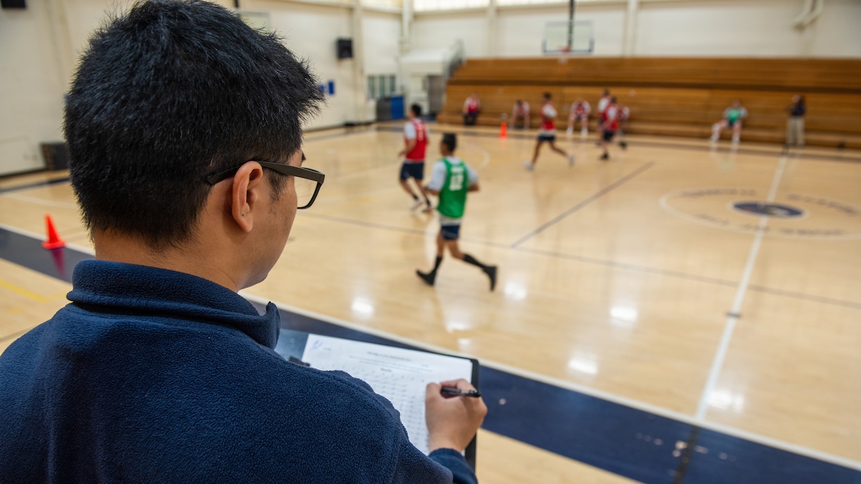 Airman observes Airmen complete run inside base gym