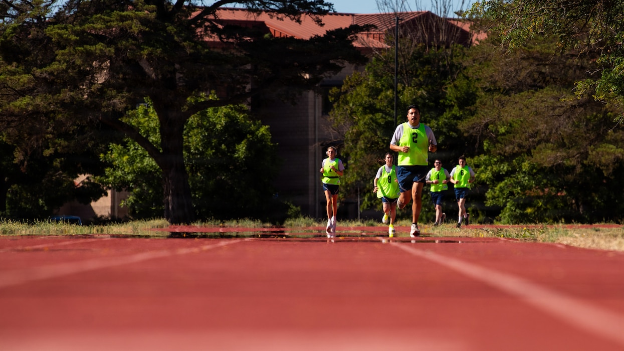 Airmen run on race track.