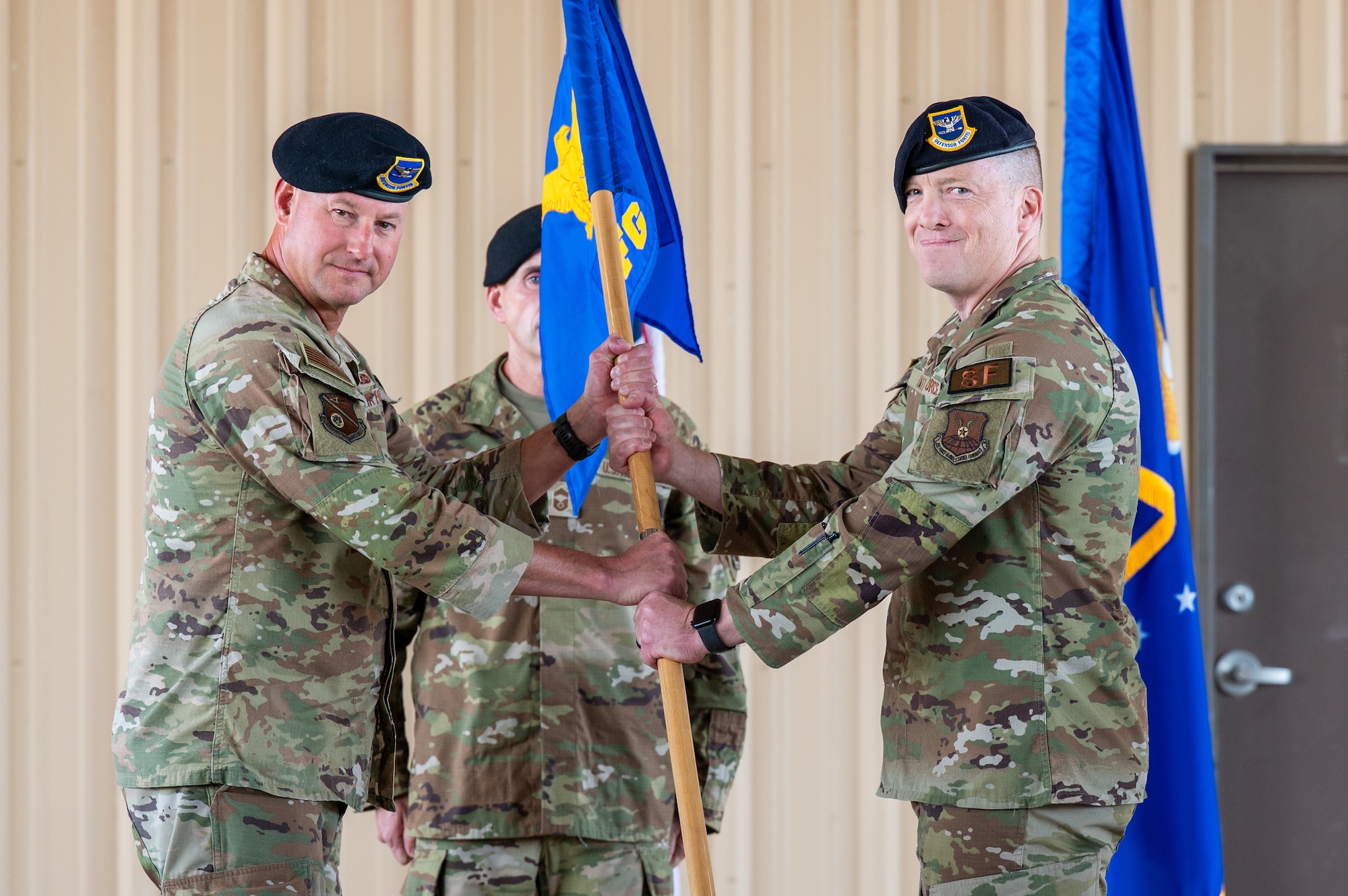 Col. Justin D. Secrest, 377th Air Base Wing and installation commander, left, passes the guidon to Col. Alexander R. Liggett, incoming 377th Security Forces Group commander, during the 377 SFG change of command ceremony at Kirtland Air Force Base, New Mexico, July 16, 2026. Liggett assumed command of the group from the outgoing commander, Col. Matthew P. Foisy. (U.S. Air Force photo by Senior Airman Donnell Schroeter)