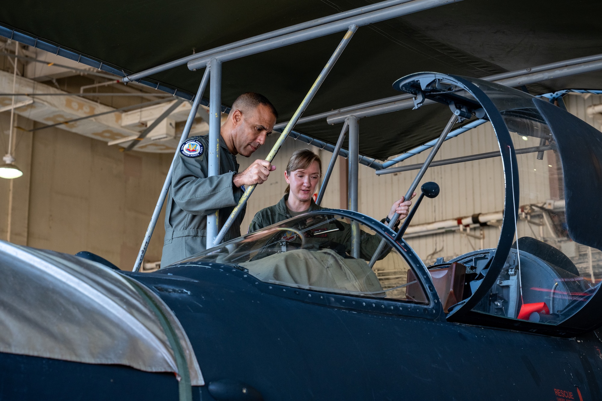 A U-2 pilot shows the cockpit to a commander.