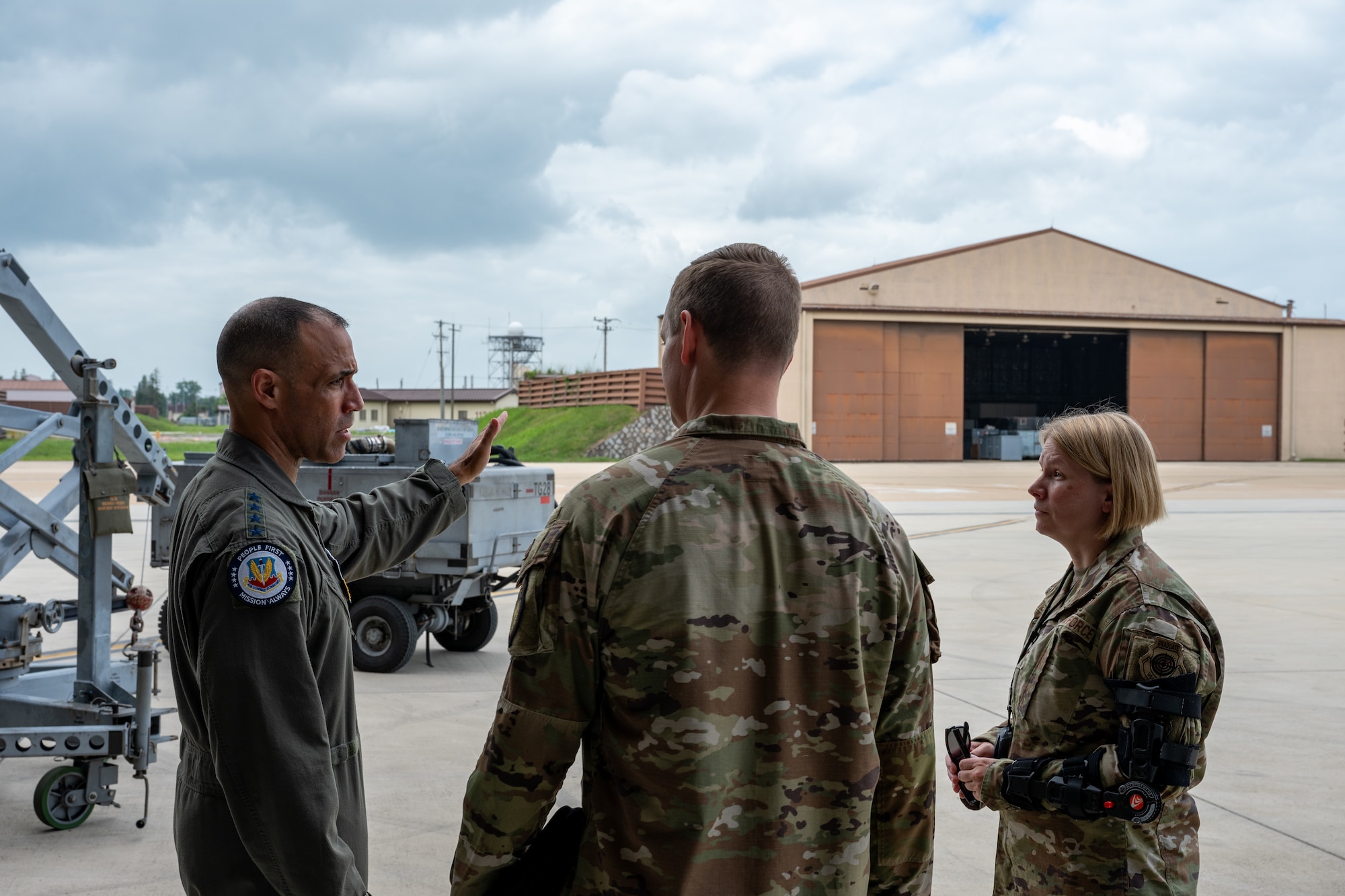 A commander points at maintenance buildings during a tour.