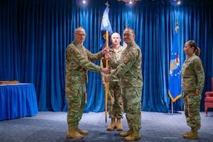 Col. Graham Warden, 374th Medical Group commander, passes the 374th Operational Medical Readiness Squadron guidon to Lt. Col. John Wu during a change of command ceremony at Yokota Air Base, Japan, July 9, 2026.