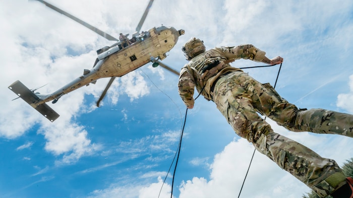 A U.S. Navy explosive ordnance disposal technician belays while a Peruvian Navy explosive ordnance disposal technician rappels during helicopter rope suspension techniques training at Bellows Air Force Station, Hawaii, during Exercise Rim of the Pacific 2026, July 13, 2026.