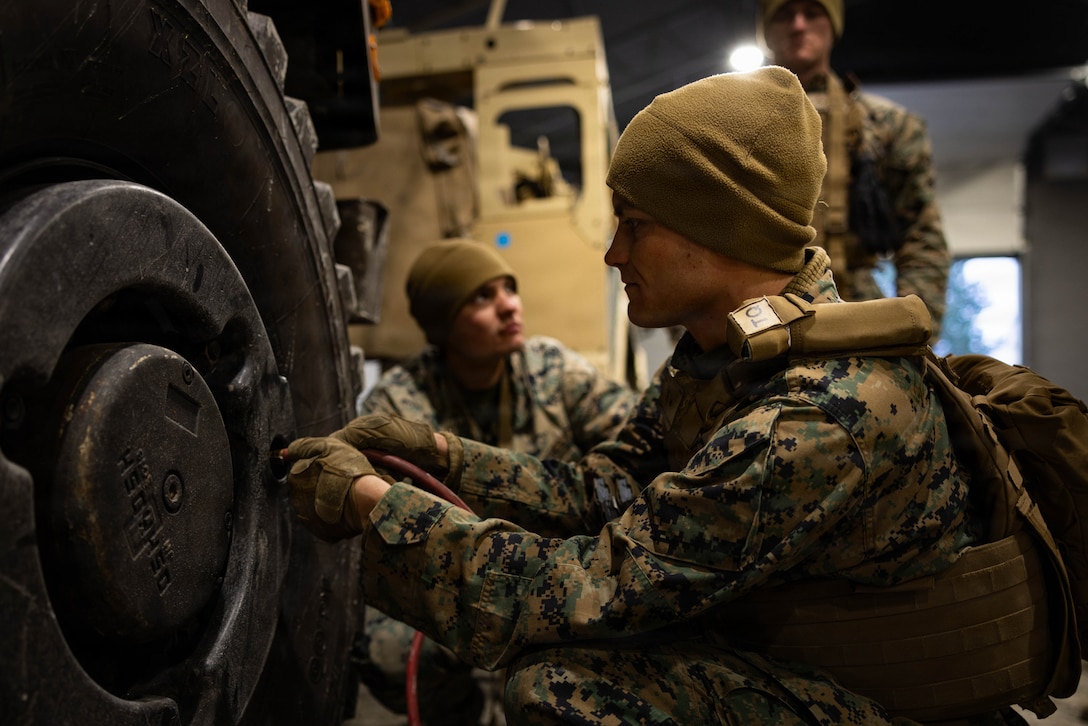 U.S. Marine Corps Lance Cpl. Paul Debruin, right, a motor vehicle operator with Combat Logistics Battalion 24, Combat Logistics Regiment 27, 2nd Marine Logistics Group, inflates a medium tactical vehicle replacement tire in Værnes, Norway, April 25, 2026. Debruin inflated the tire before a long-range convoy during exercise Aurora 26. U.S. Marines and Sailors with 2nd MLG are participating in exercise Aurora as part of the larger U.S. Army-led Sword 26 series of linked multinational exercises, which directly supports NATO's Eastern Flank Deterrence Initiative concept, validates defense plans, builds a unified lethal force, and strengthens deterrence. Debruin is a native of Iowa. (U.S. Marine Corps photo by Lance Cpl. Brady Hathaway)