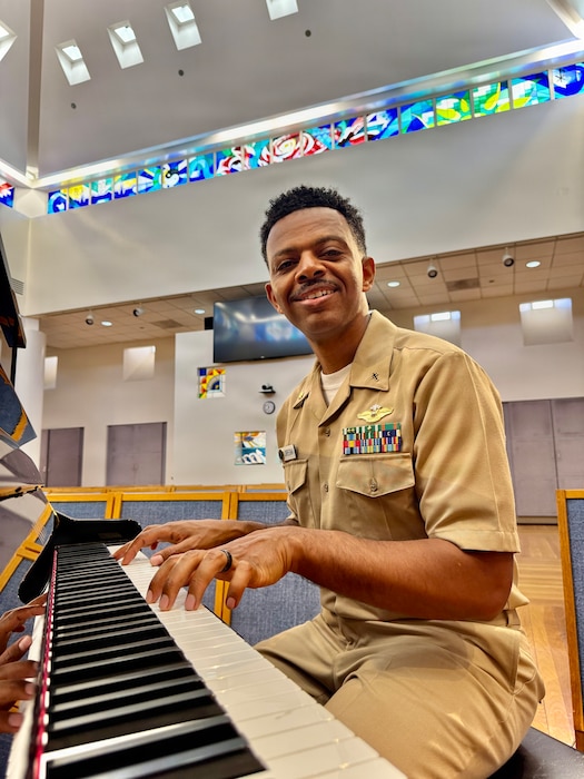 Lt. Cmdr. Abraham Jiregna plays the piano at Navy Medicine Readiness and Training Command San Diego, June 1, 2026. As a clinical pastoral education resident chaplain, Jiregna established a new music-informed spiritual care program that integrates AI-assisted music to create a therapeutic experience for warfighters navigating mental health challenges. (Courtesy photo)