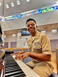 Lt. Cmdr. Abraham Jiregna plays the piano at Navy Medicine Readiness and Training Command San Diego, June 1, 2026. As a clinical pastoral education resident chaplain, Jiregna established a new music-informed spiritual care program that integrates AI-assisted music to create a therapeutic experience for warfighters navigating mental health challenges. (Courtesy photo)