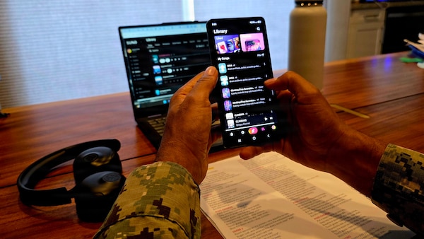 Lt. Cmdr. Abraham Jiregna organizes his catalog of AI-assisted music at Navy Medicine Readiness and Training Command San Diego, May 27, 2026. Jiregna, a clinical pastoral education resident chaplain, has generated more than 300 original songs to support his music-informed spiritual care sessions, helping service members process emotional and spiritual challenges. (Courtesy photo)