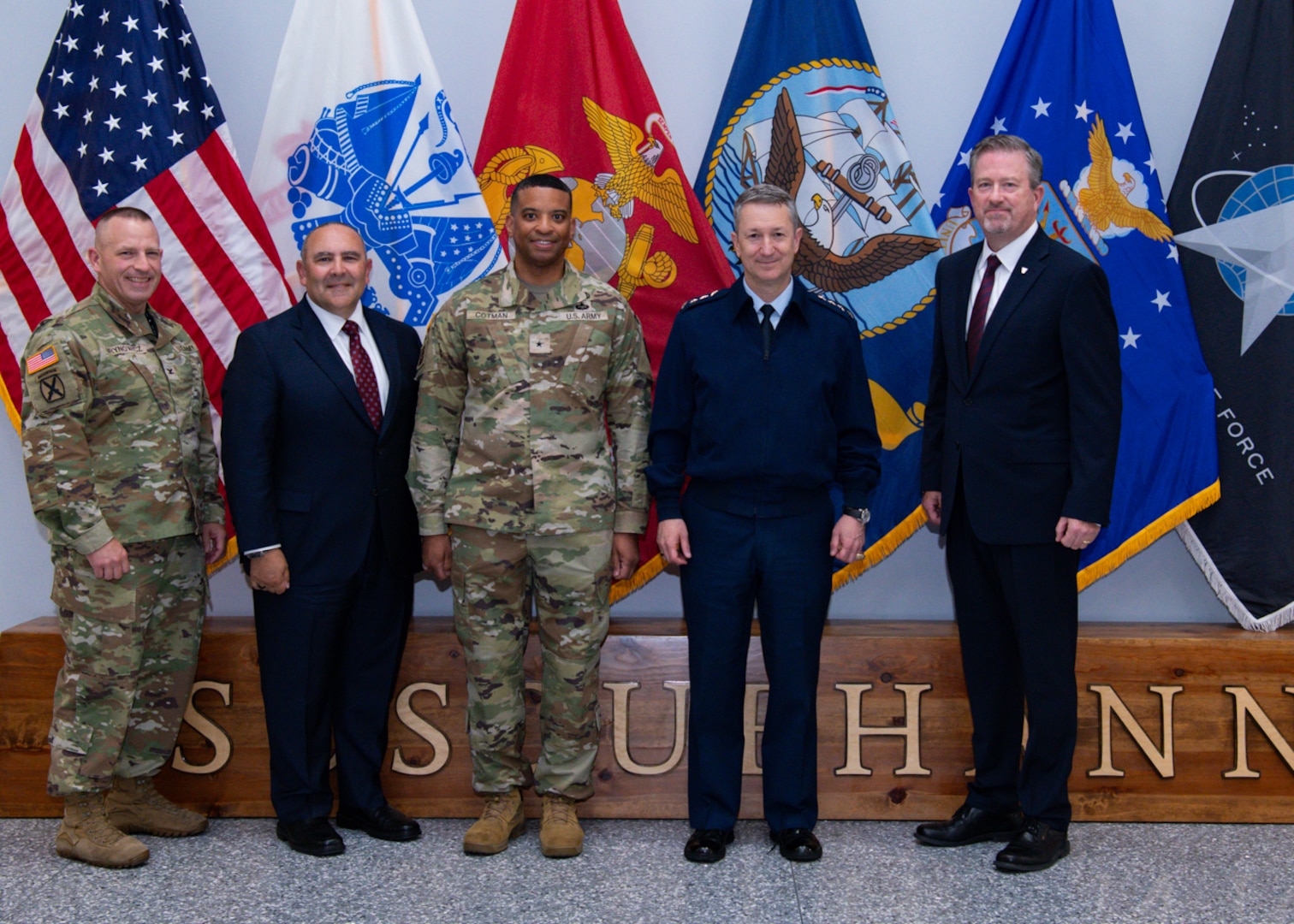 A group photo in front of flags.