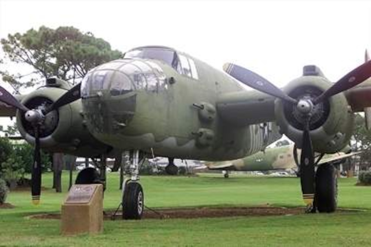 An airplane is displayed in a grassy field.