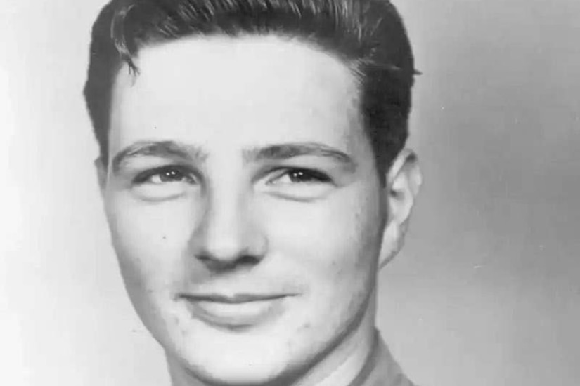 A black and white photo of a man posing for a photo while wearing a military uniform.
