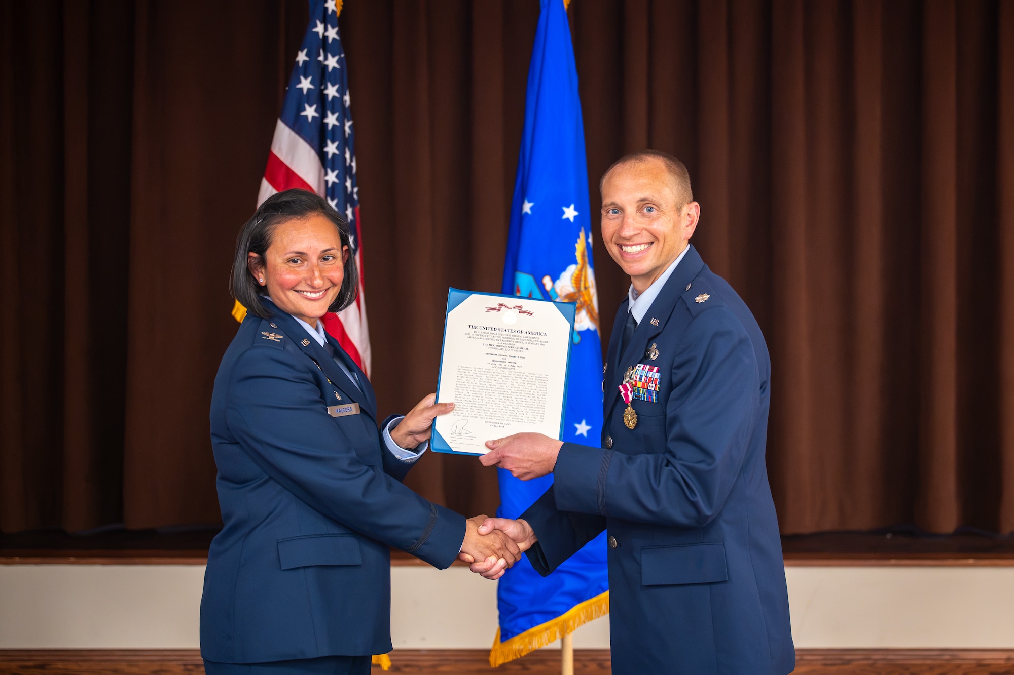 Col. Zarine E. Malesra, Geospatial and Signatures Intelligence Group commander, presents an award to Lt. Col. Robert Vogt, outgoing Geospatial Intelligence Analysis Squadron commander, during a change of command ceremony at Wright-Patterson Air Force Base, Ohio, July 1, 2026. Vogt was recognized for his outstanding leadership and dedication to the creation of tailored, geospatially-based intelligence. (U.S. Air Force photo by Staff Sgt. Kristof J. Rixmann)