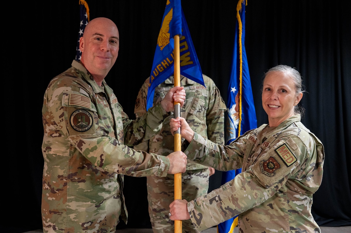 Col. Eric Bissonette is presented the Laughlin Medical Group guidon from Col. Kelly Vermillion.