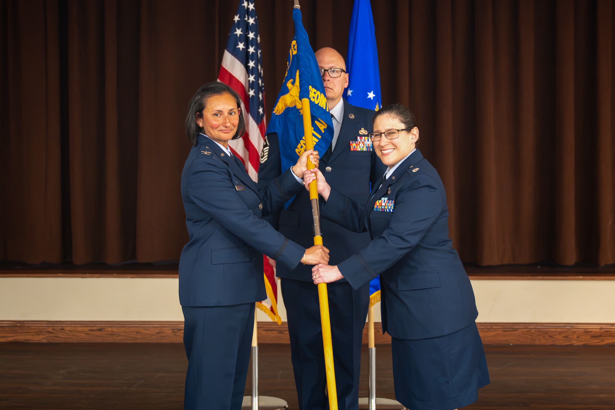 Lt. Col. Alicia Delia, right, takes command of the Geospatial Intelligence Analysis Squadron after receiving the guidon from Col. Zarine E. Malesra, Geospatial and Signatures Intelligence Group commander, at Wright-Patterson Air Force Base, Ohio, July 1, 2026. By accepting the guidon, Delia formally takes charge of the squadron and its vision to be the premier provider for geospatially-based intelligence. (U.S. Air Force photo by Staff Sgt. Kristof J. Rixmann)