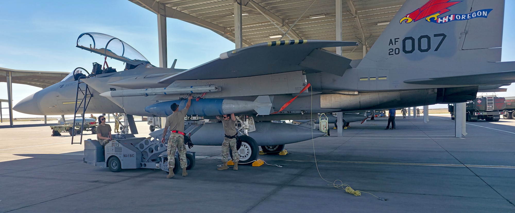 A BDU-56 "bomb" is loaded onto an F-15 EX Eagle II aircraft assigned to the Oregon Air National Guard's 142nd Wing during a training mission at Mountain Home Air Force Base, Idaho, May 2026. The 142nd Wing is the first operational EX unit in the U.S. military. During this training mission, the wing took a significant step toward expanding the EX's operational capacity by demonstrating its air-to-ground capability.