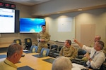 Cadet Grant Feldman (U.S. Air Force Academy) engages with Will Reinhart, J-3 operations director, during his final research project presentation at United States Military Entrance Processing Command. Through the Cadet Summer Research Program, service academy cadets contribute innovative ideas while gaining valuable experience supporting USMEPCOM's mission.
