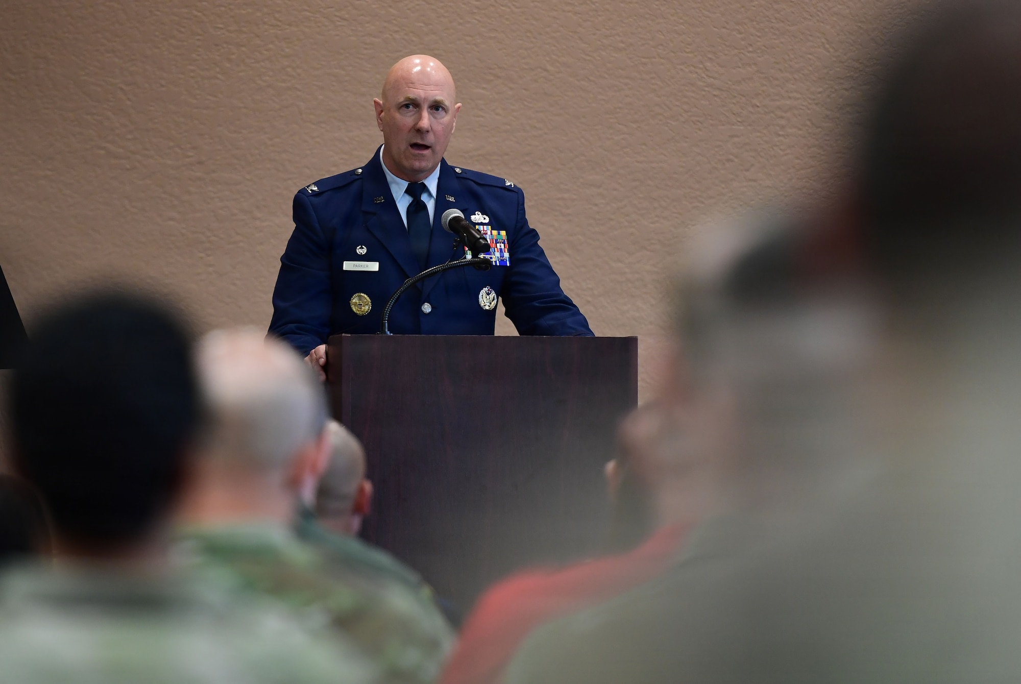 A man in a U.S. Air Force uniform speaks from a podium.