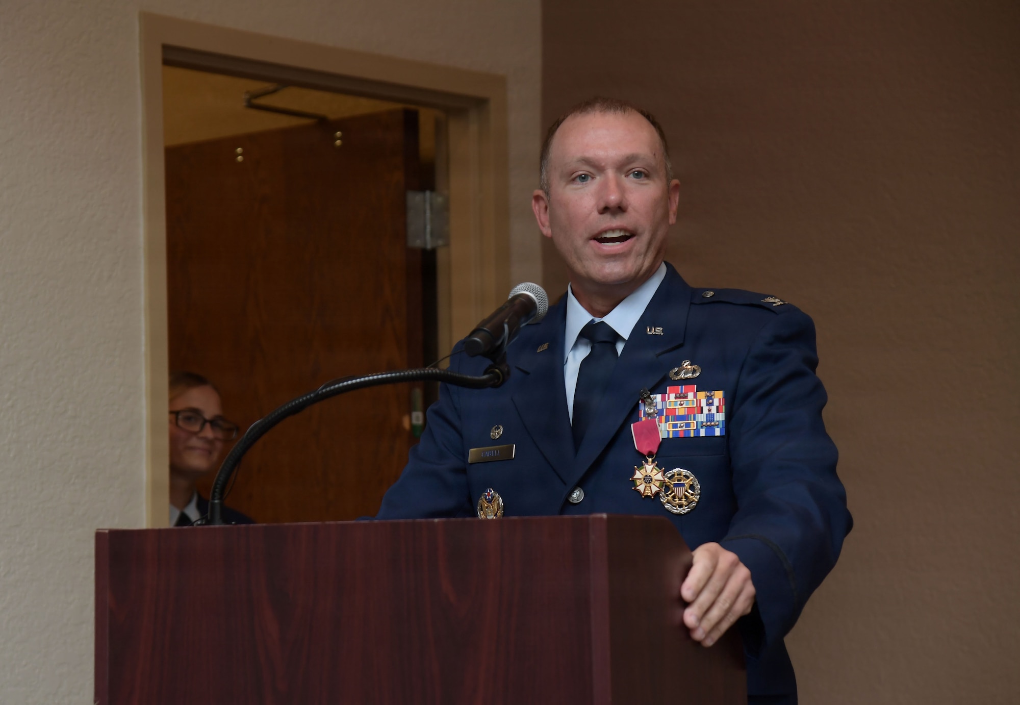 A man in U.S. Air Force uniform speaks from a podium.