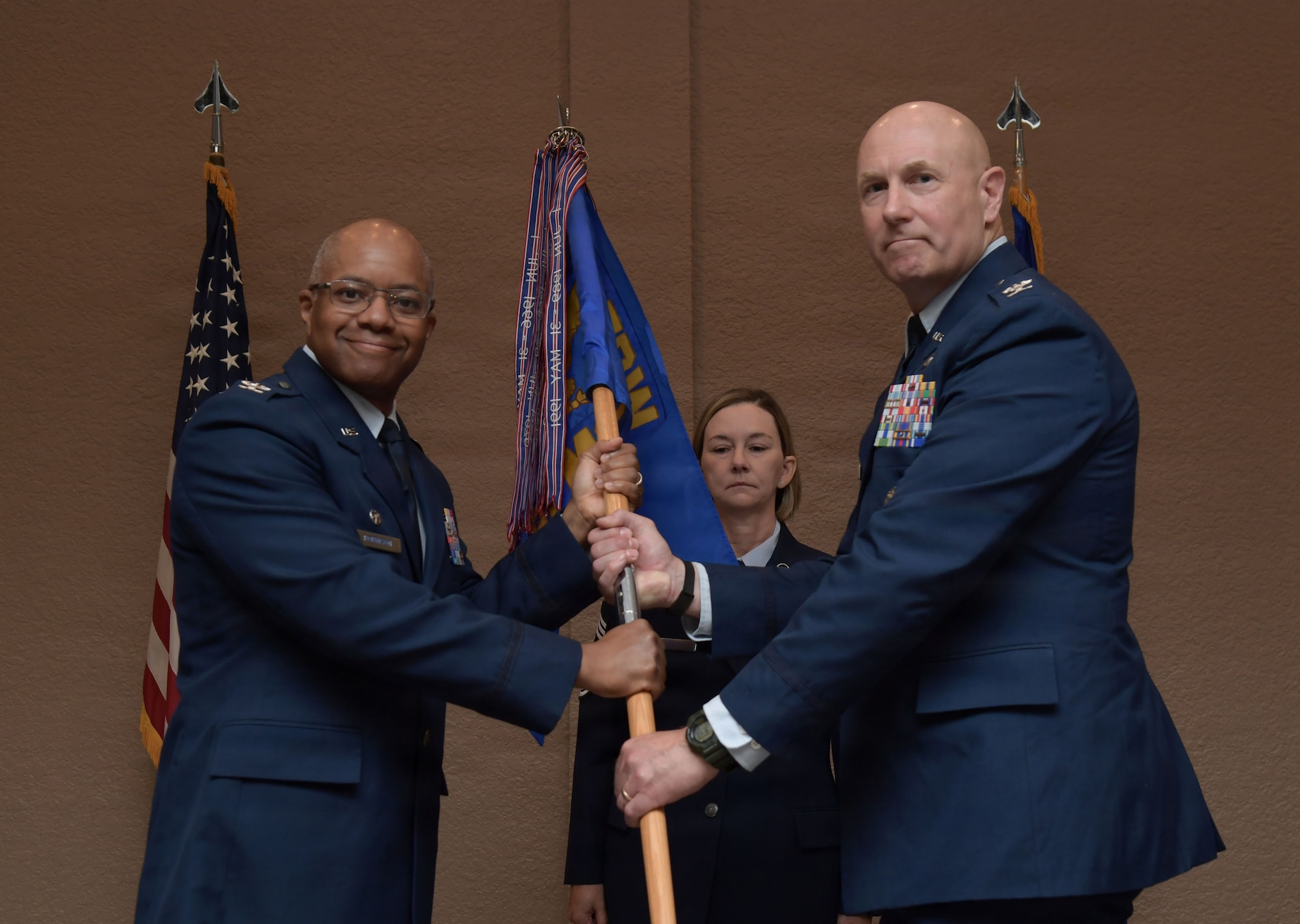 Two men in U.S. Air Force uniforms hold on to a guidon.