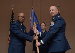 Two men in U.S. Air Force uniforms hold on to a guidon.