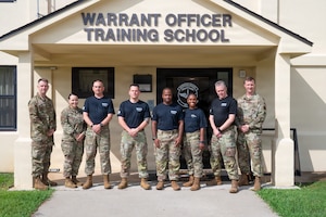 From left, U.S. Air Force Lt. Col. Tanner Allshouse, Warrant Officer Training School (WOTS) commandant; Master Sgt. Kate Hytinen, WOTS instructor; Senior Master Sgt. Kevin Johnson, Chief Warrant Officer 2 Jonathan Miller, Master Sgt. Ernest Brown and Tech. Sgt. Staci Starks-Miller, graduates of the Air Force Train, Advise, Coach Officer program and future WOTS cadre members; Master Sgt. Ryan Knight, WOTS instructor; and Chief Warrant Officer 5 Jason Godwin, WOTS advisor to the commandant, pose for a photo following the program's graduation ceremony at Maxwell Air Force Base, Alabama, July 15, 2026.