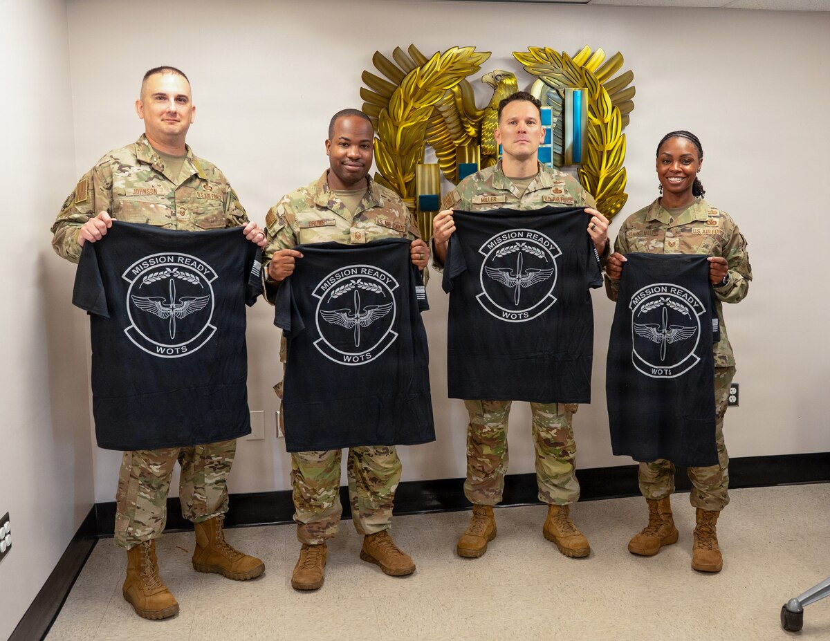 U.S. Air Force Senior Master Sgt. Kevin Johnson, Master Sgt. Ernest Brown, Chief Warrant Officer 2 Jonathan Miller and Tech. Sgt. Staci Starks-Miller, graduates of the Air Force Train, Advise, Coach Officer program and future Warrant Officer Training School cadre members, pose for a photo following their graduation at Maxwell Air Force Base, Alabama, July 15, 2026.
