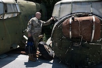 U.S. Air Force Senior Master Sgt. Matthew Foulk, a munitions flight senior enlisted leader assigned to the 177th Fighter Wing, New Jersey Air National Guard, explores a MiG aircraft graveyard during a tour at Kuçovë Air Base, Albania, July 15, 2026.