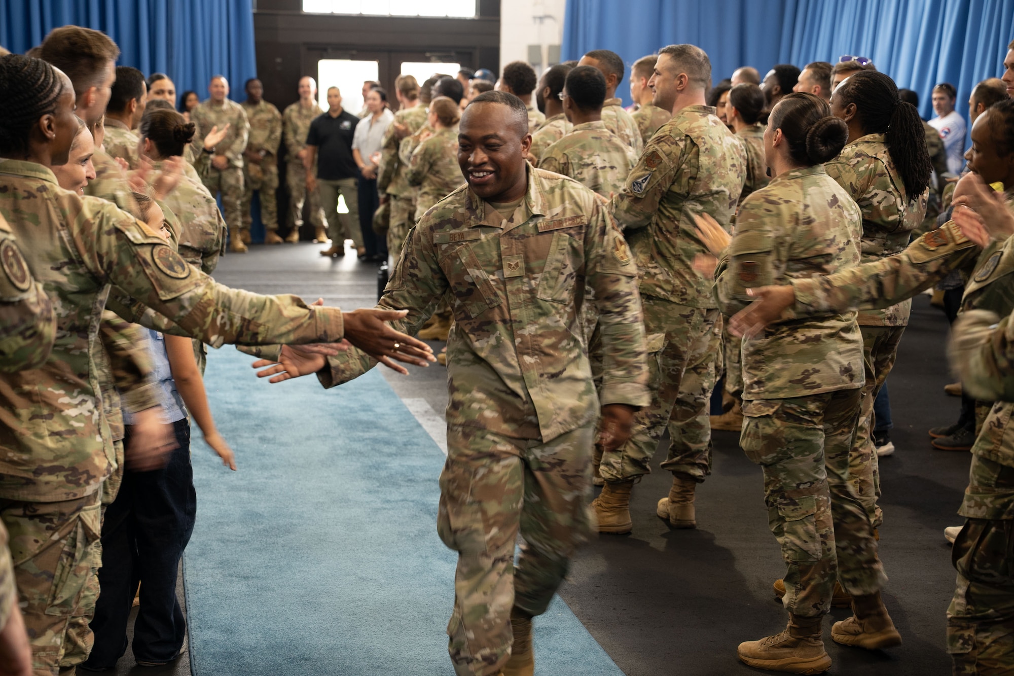 Technical Sergeant selectee walks down and high-fives attendees.