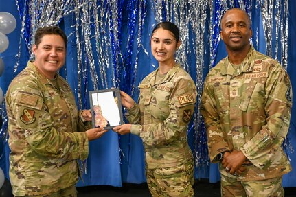 Technical Sergeant selectee poses with deputy commander, left, and command chief, right.