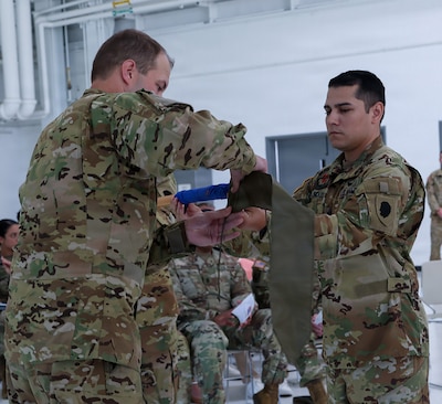 Capt. Jonathan Mercado, right, Commander, Detachment 2, Company G, 1-111th General Aviation Support Battalion, and Sgt. 1st Class Timothy Panatera, acting first sergeant, case the unit's guidon during a ceremony July 12 at the Army Aviation Support Facility in Kankakee.