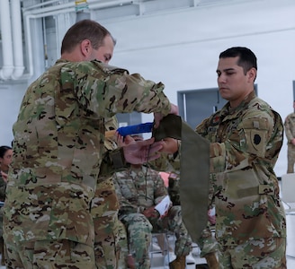 Capt. Jonathan Mercado, right, Commander, Detachment 2, Company G, 1-111th General Aviation Support Battalion, and Sgt. 1st Class Timothy Panatera, acting first sergeant, case the unit's guidon during a ceremony July 12 at the Army Aviation Support Facility in Kankakee.