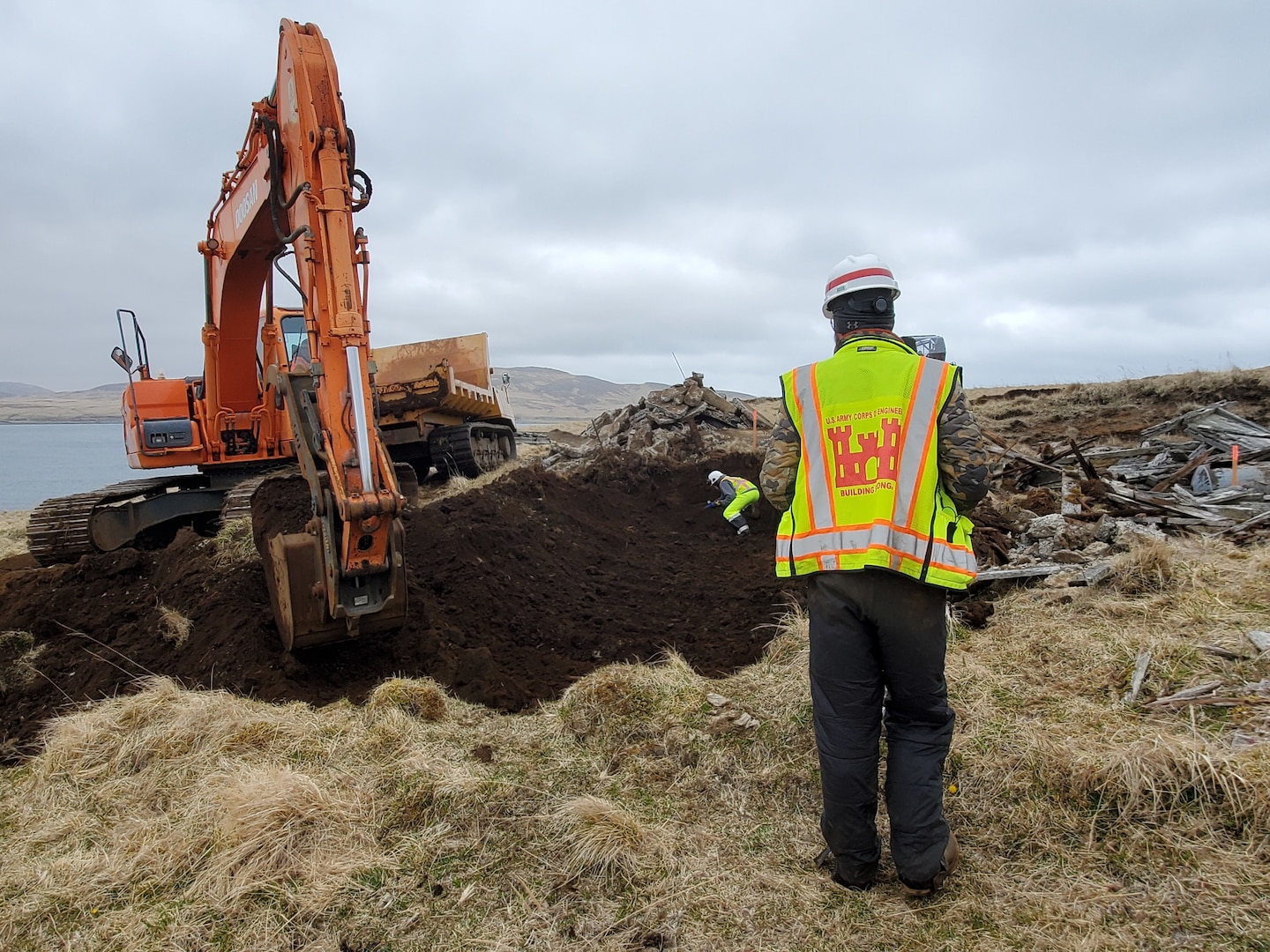 A man and an excavator meet on opposite sides of a hole. The situation is tense.