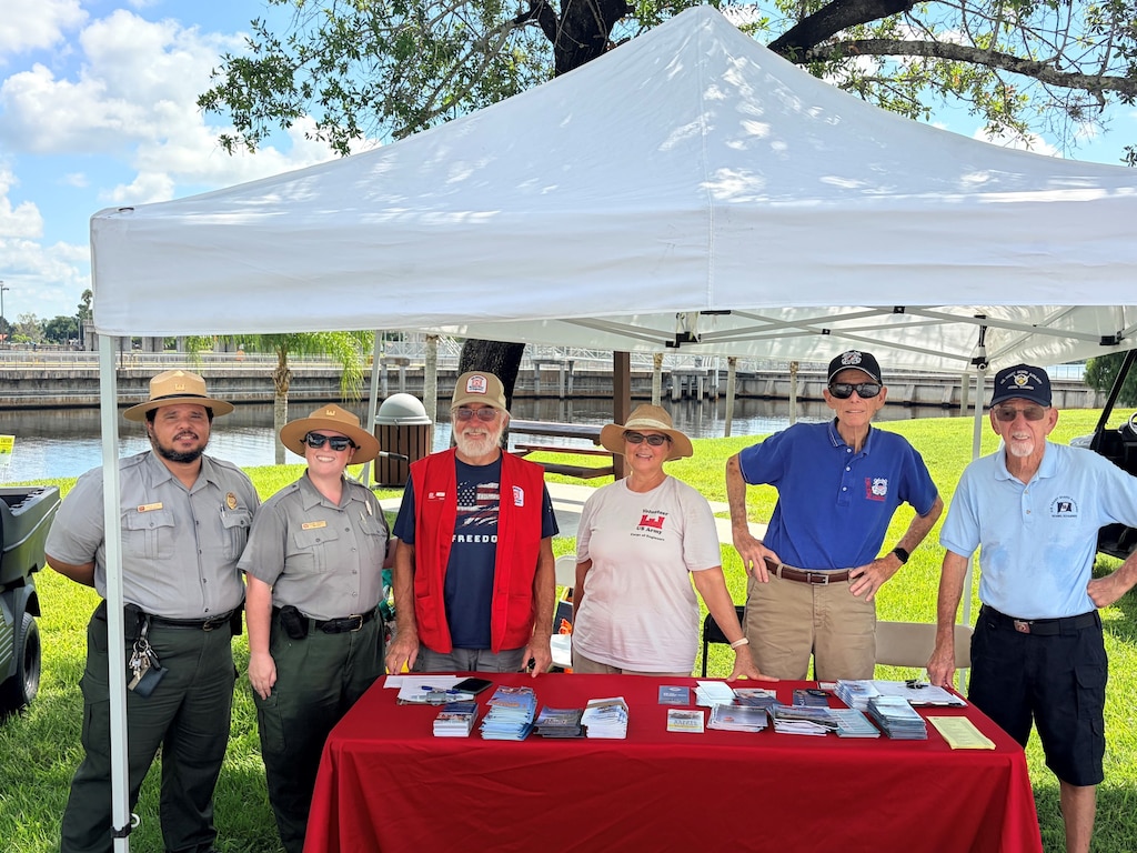 From left, U.S. Army Corps of Engineers Jacksonville District Park Ranger Jorge Leyro-Montalvo, Lead Park Ranger Megan Parsons, USACE volunteers Joe and Cheryl, and U.S. Coast Guard Auxiliary members John and Jim pose during a Fourth of July water safety outreach event at the W.P. Franklin South boat ramp in Alva, Florida, July 4, 2026. The partnership provided free vessel safety examinations, life jacket outreach and boating safety education to holiday visitors. (U.S. Army Corps of Engineers photo)
