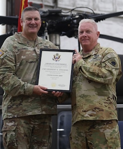 Brig Gen. Lenny Williams, left, Assistant Adjutant General – Army and Commander of the Illinois Army National Guard, presents a certificate of retirement to Chief Warrant Officer 5 Herb Stevens, State Standardization Pilot and Commander of the Army Aviation Support Facility (AASF) 1 in Kankakee, during a retirement ceremony July 16 at AASF 2 in Decatur.