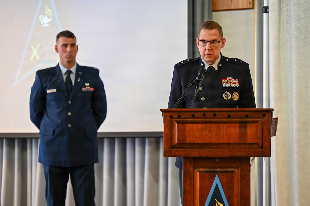 Man at podium and another behind him in Space Force uniforms