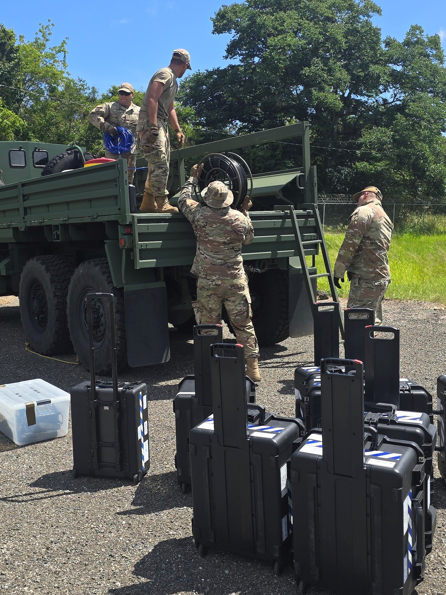 U.S. Airmen with the 156th Combat Communication Squadron, Puerto Rico Air National Guard, offload equipment from a 5 ton truck during exercise FUNKY BUSINESS at the 130th Engineer Battalion, Vega Baja, Puerto Rico, June 4, 2026. The exercise tested Airmen's ability to rapidly establish expeditionary communications and sustain mission readiness through realistic deployment operations and disciplined logistical procedures. (U.S. Air National Guard courtesy photo)