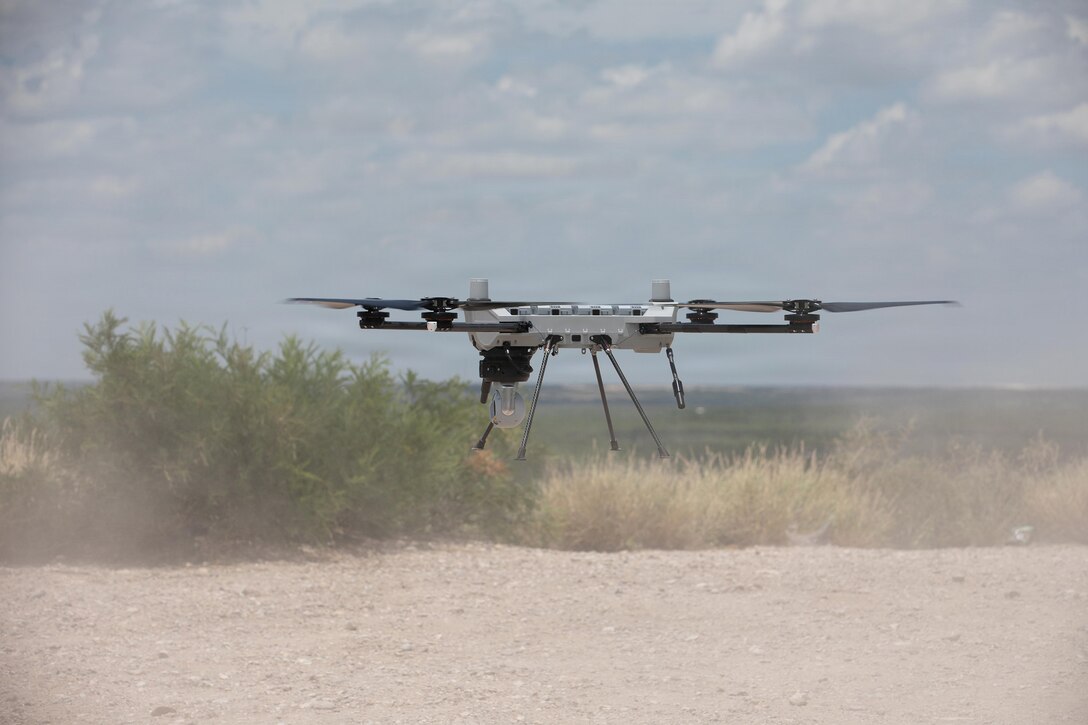 A ground hovers over flat dirt terrain.