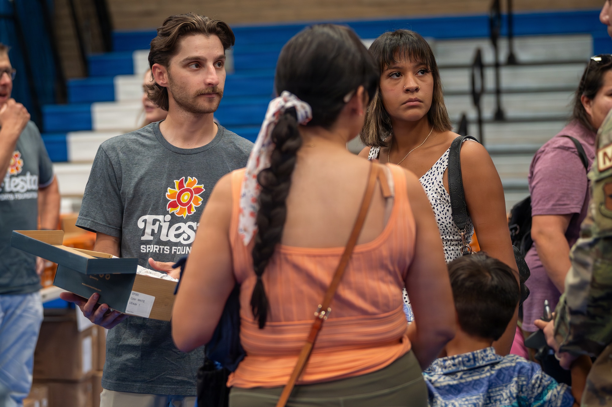A volunteer helps a military family pick a pair of shoes during the Back to School Bash held at Luke Air Force Base, Arizona, July 14, 2026.