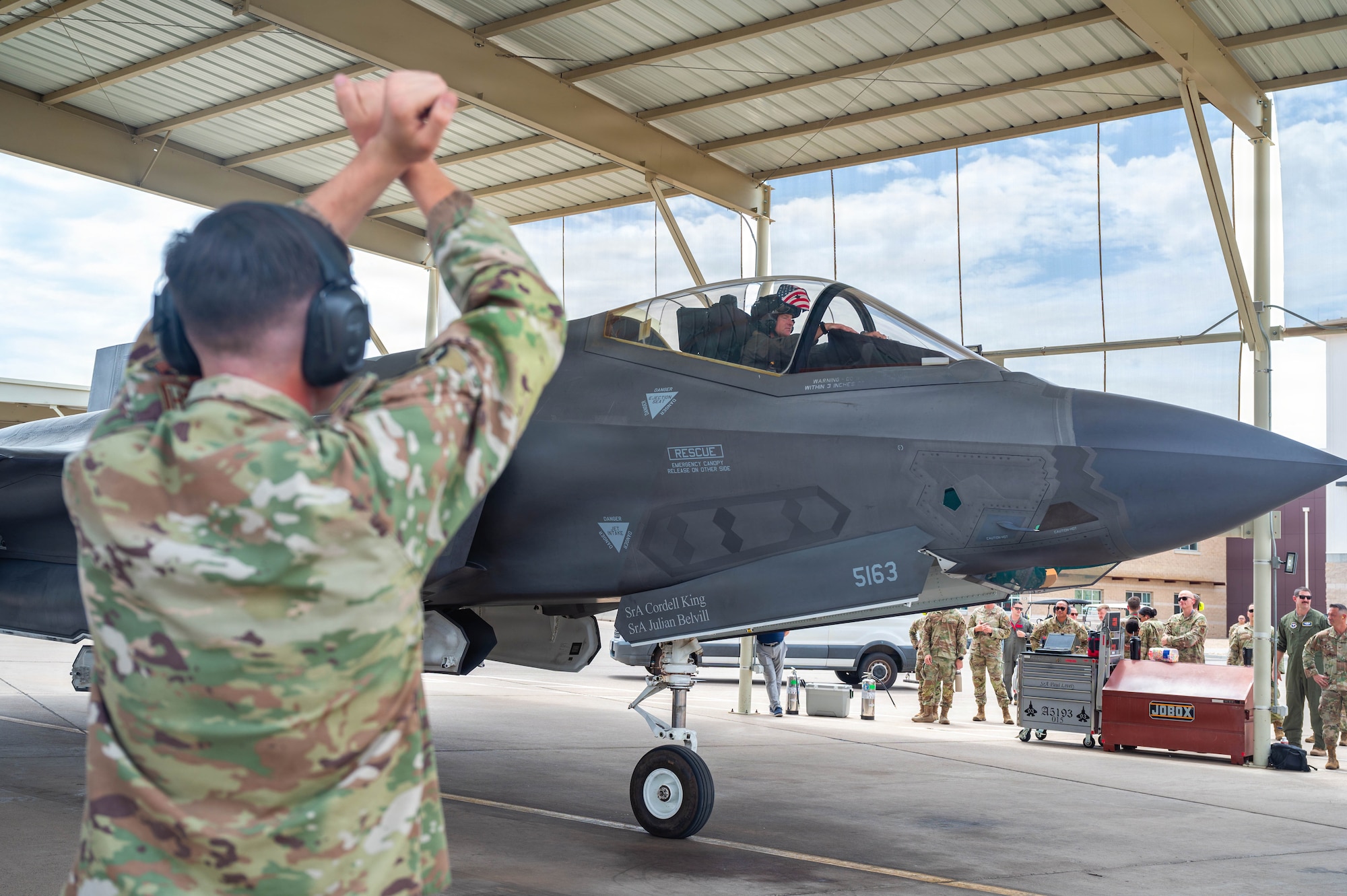 A U.S. Airmen guides an F-35A Lightning II into a parking space.
