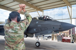 A U.S. Airmen guides an F-35A Lightning II into a parking space.