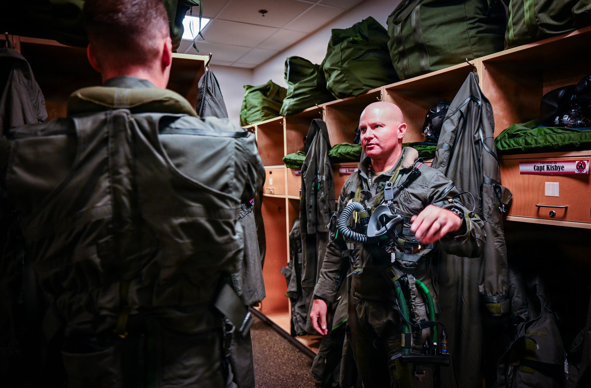 U.S. Airmen put on flight equipment before a flight.