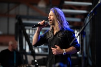 Jeff Vezain, Lt. Dan Band vocalist, sings during concert at Holloman Air Force Base, New Mexico, July 12, 2026. The band regularly visits military installations around the world to support service members and their families through music and outreach. (U.S. Air Force photo by Senior Airman Michelle Ferrari)