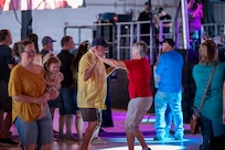 Attendees dance and celebrate during a concert at Holloman Air Force Base, New Mexico, July 12, 2026. Through the Gary Sinise Foundation, Sinise has helped raise over $300 million to support disabled veterans, first responders and their families. (U.S. Air Force photo by Senior Airman Michelle Ferrari)