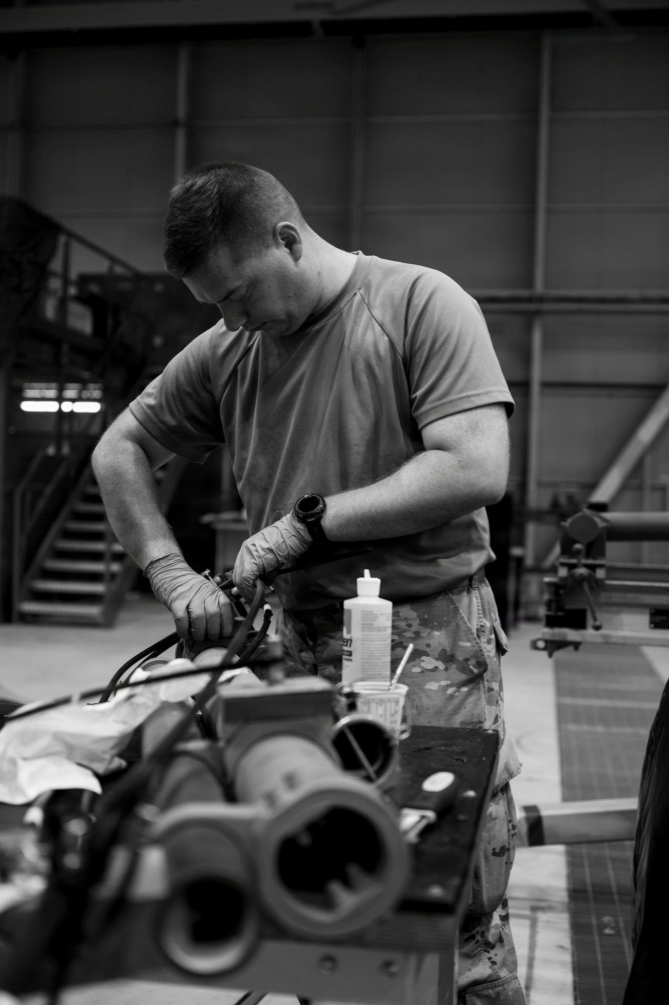 A man connects internal helicopter components during maintenance.