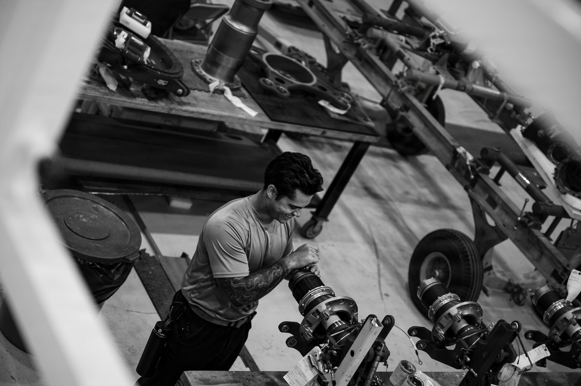A man twists a component on a helicopter part.
