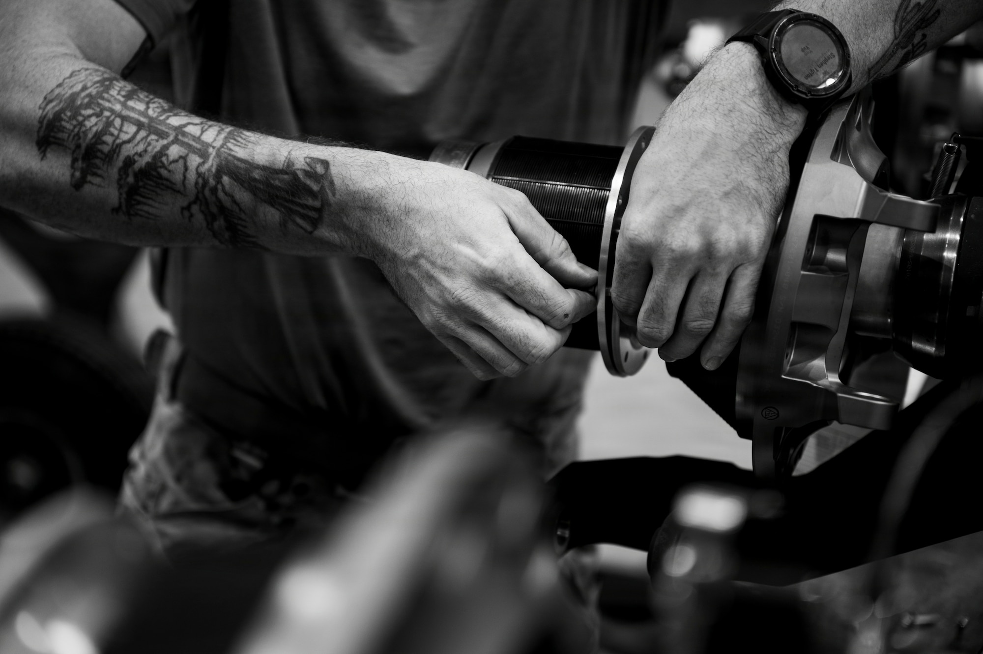 A man's hands twist a part for a helicopter.