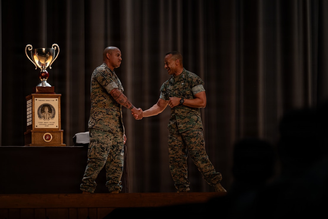 U.S. Marine Corps Lt. Gen. Calvert L. Worth Jr., right, the commanding general of II Marine Expeditionary Force, shakes hands with Gunnery Sgt. Angel Garcia, a logistics chief with Combat Logistics Battalion 24, Combat Logistics Regiment 27, 2nd Marine Logistics Group, after Garcia was recognized during an award ceremony at Marine Corps Base Camp Lejeune, North Carolina, July 17, 2026. The Lieutenant General “Chesty” Puller award is awarded to units within II Marine Expeditionary Force that have showcased outstanding ability and superior performance in supporting the mission of II MEF within the past year. Worth is a native of Missouri. Garcia is a native of New Jersey. (U.S. Marine Corps photo by Lance Cpl. Brady Hathaway)