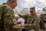 Minnesota National Guard Brig. Gen. Joseph Sharkey, the 34th Infantry Division commander, serves steaks to multinational partners during Exercise Combat Power 26, June 23-July 1, 2026, in Croatia. A steak dinner was provided by Serving Our Troops for the 30th Anniversary dinner between Minnesota and Croatia partnership under the Department of War National Guard Bureau State Partnership Program. Photo by Staff Sgt. Mahsima Alkamooneh.