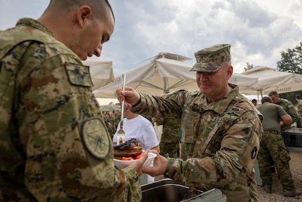 Minnesota National Guard Brig. Gen. Joseph Sharkey, the 34th Infantry Division commander, serves steaks to multinational partners during Exercise Combat Power 26, June 23-July 1, 2026, in Croatia.