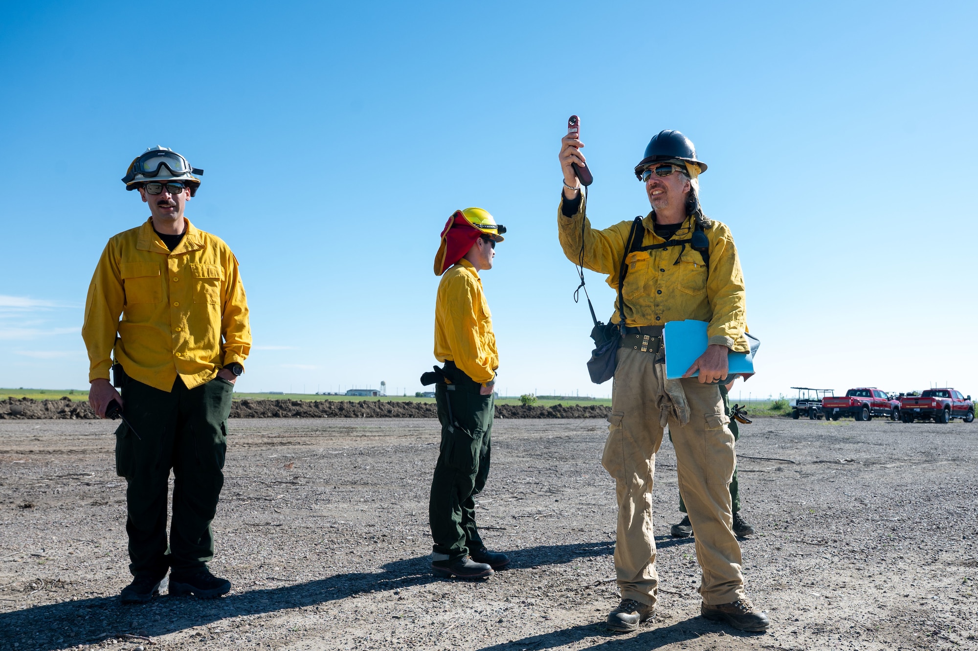 U.S. Air Force Tech. Sgt. Jordan Herrick, 341st Civil Engineer Squadron assistant chief of health and safety, left, and Bela Harrington, Air Force Civil Engineer Center Wildland Support Module area fire management officer, right, evaluate wind conditions for a prescribed burn at Malmstrom Air Force Base, Montana, July 8, 2026.